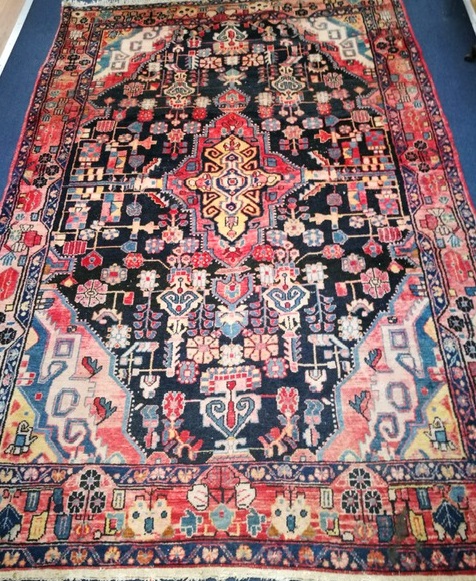 A Persian red ground rug with triple blue diagonal centre 245 x 189cm
